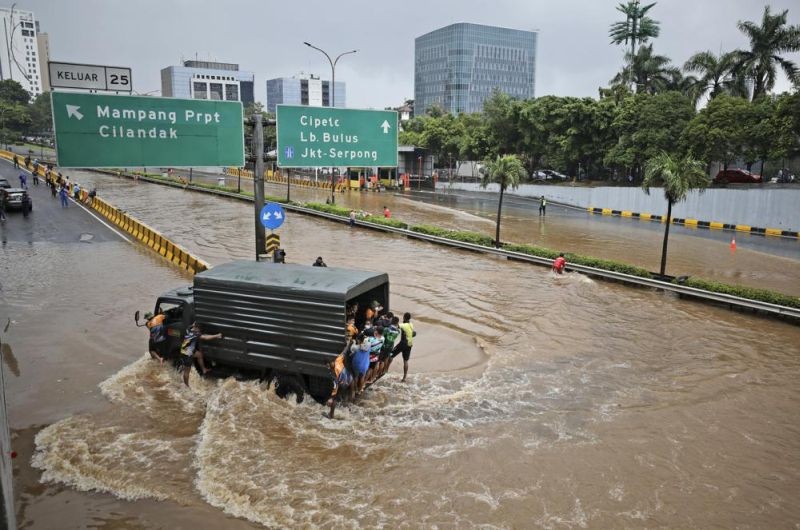 A military truck drives through the water on a flooded toll road following heavy rains in Jakarta, Indonesia on February 20, 2021. (AP Photo)